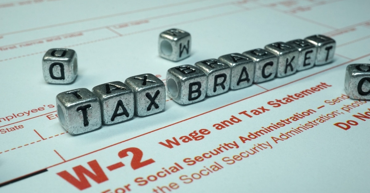 Financial consultant explaining tax brackets to a business owner with charts and documents