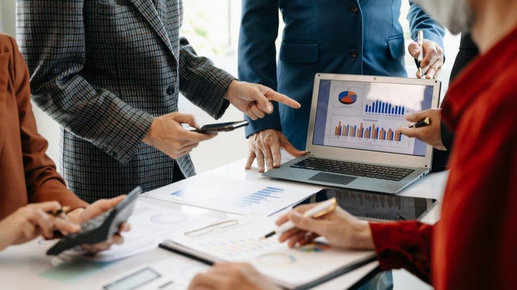 Financial professional analyzing financial statements on a desk with charts and graphs